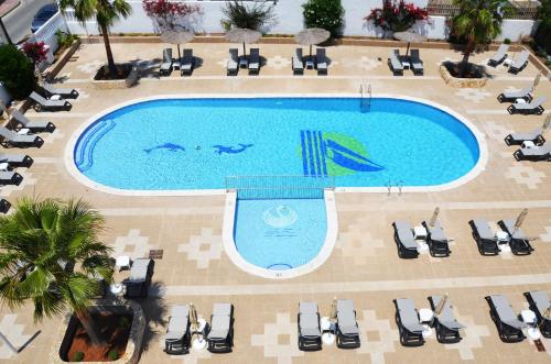 an overhead view of a swimming pool with chaise lounges at Hotel Apartamentos Vibra San Marino in San Antonio Bay