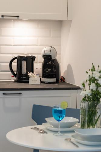 a table with a coffee maker and a glass on it at Apartments Mazowiecka Pobierowo by Noclegi Renters in Pobierowo