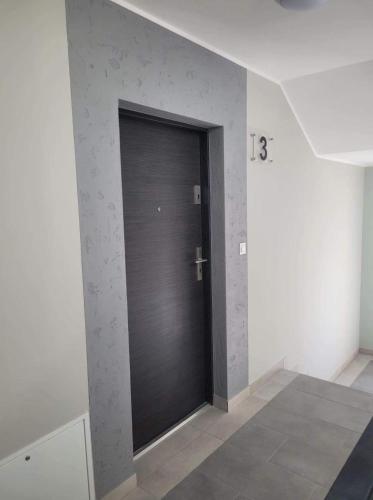 a black door in a room with a wall at Kawalerka Wałowa 3 in Wejherowo