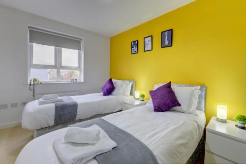 2 Betten in einem Zimmer mit gelber Wand in der Unterkunft Honeysuckle Road in Sheffield