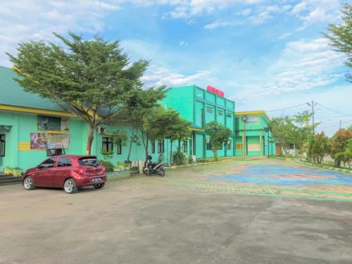 a red car parked in front of a building at Edotel SMKN 2 Pinrang Mitra RedDoorz in Pinrang
