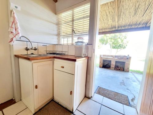 a kitchen with a sink and a large window at Kwetu Guest Farm in Swellendam