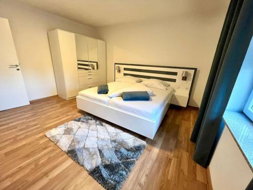 a bedroom with a white bed and a rug at AB Apartment Moderne Zweizimmerwohnung in Villach