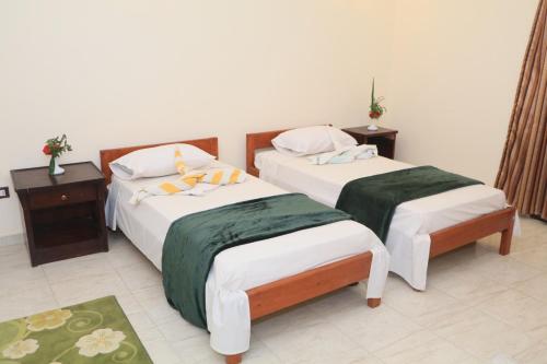 2 camas en una habitación con 2 mesitas de noche en Masa House en Luxor