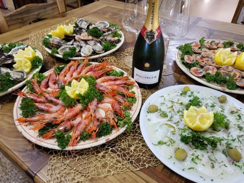 a table with plates of seafood and a bottle of wine at Hotel Salento in Specchia