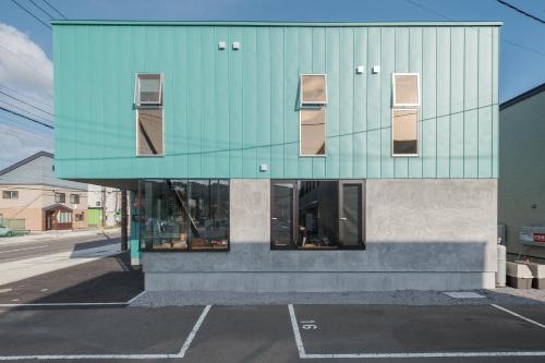 a building with a glass facade on a street at Tbox in Kutchan