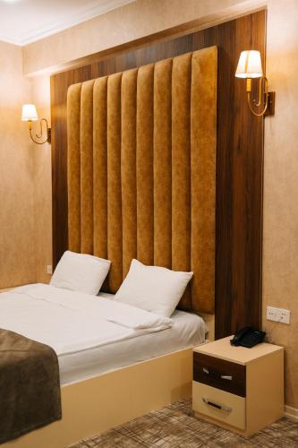 a hotel room with two beds and a large headboard at The Clocktower Hotel in Baku