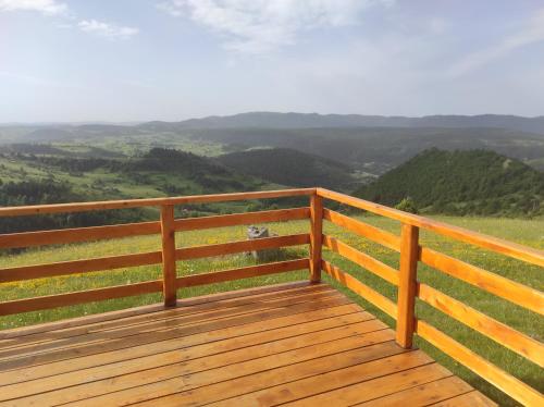 a wooden deck with a view of the mountains at Zlatarski raj in Muškovina