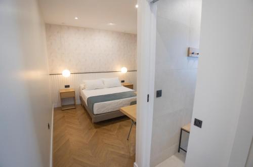 a bedroom with a bed and a room with a hallway at OIKOS APARTAMENTOS TURÍSTICOS in Monesterio