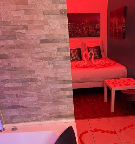 - une chambre avec un mur en briques et un lit avec une baignoire dans l'établissement SPA Enzo Appartement avec Jacuzzi Privatif, à Lyon