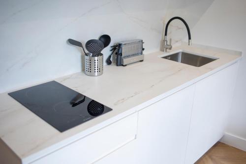a white kitchen counter with a sink and a sink at OIKOS APARTAMENTOS TURÍSTICOS in Monesterio