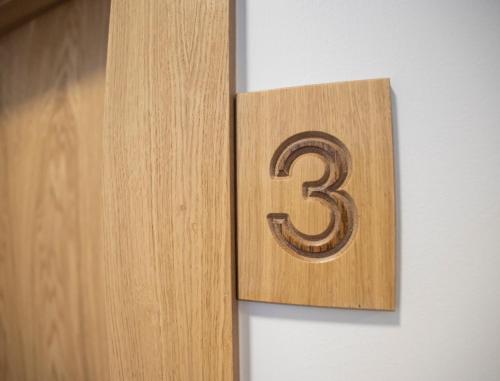 a wooden number three hanging on a wall at OIKOS APARTAMENTOS TURÍSTICOS in Monesterio