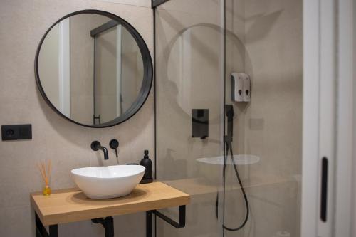 a bathroom with a sink and a mirror at OIKOS APARTAMENTOS TURÍSTICOS in Monesterio
