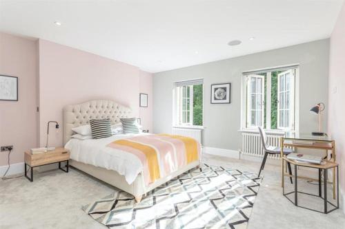 a white bedroom with a bed and a desk at Stylish Home - Wentworth, Sunningdale Golf Club in Sunninghill