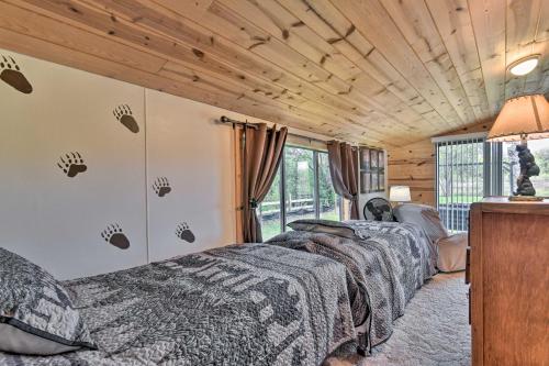 2 Betten in einem Zimmer mit Holzdecken in der Unterkunft Charming Gladwin Family Cottage - Indian Lake in Gladwin