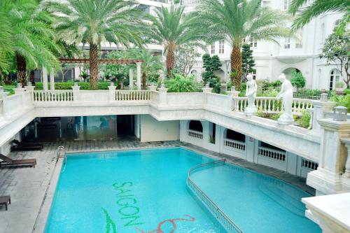 a large swimming pool in a building with palm trees at Hello World Saigon in Ho Chi Minh City