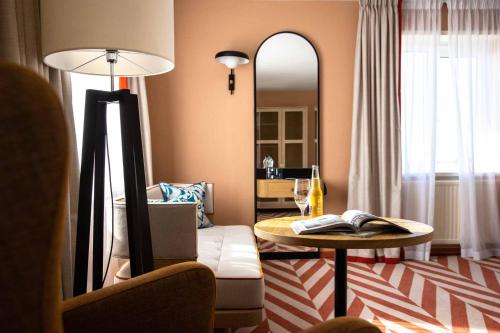 a living room with a table and a mirror at The Relais Cooden Beach and Spa in Bexhill