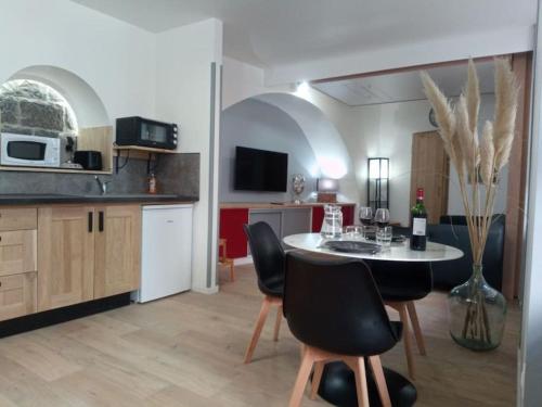 eine Küche mit einem Tisch und Stühlen im Zimmer in der Unterkunft studio entre terre et ciel - escapade millavoise in Millau