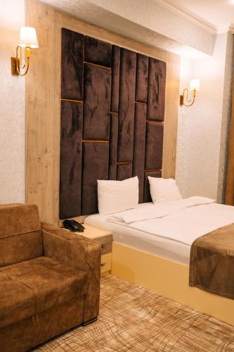 a hotel room with two beds and a couch at The Clocktower Hotel in Baku