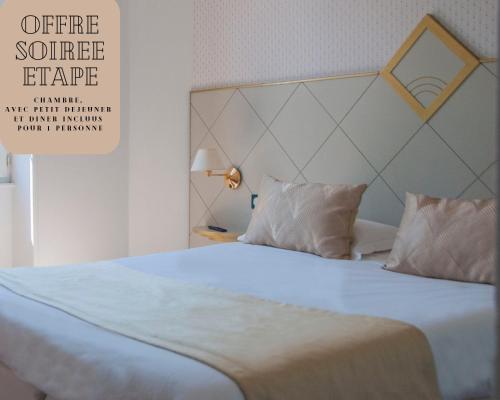 a bed with white sheets and pillows in a room at The Originals City, Hôtel Bristol, Le Puy-en-Velay in Le Puy en Velay