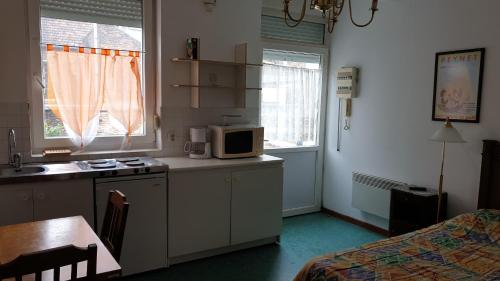 cocina con microondas y mesa en una habitación en Au Relais Des Thermes, en Saint-Amand-les-Eaux