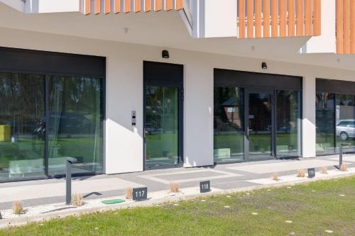 a facade of a building with glass windows at Apartments Mazowiecka Pobierowo by Noclegi Renters in Pobierowo