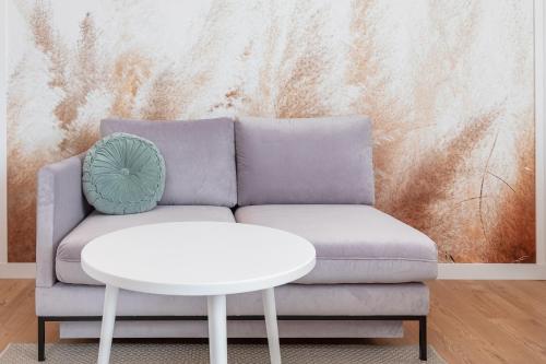 a living room with a couch and a table at Apartments Mazowiecka Pobierowo by Noclegi Renters in Pobierowo