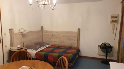 um pequeno quarto com uma cama e uma mesa em Au Relais Des Thermes em Saint-Amand-les-Eaux