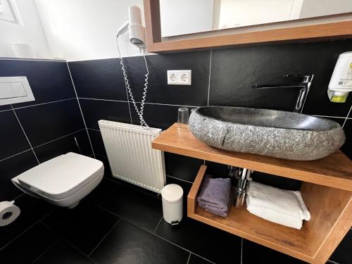 a bathroom with a sink and a toilet at Landhaus Hohly in Löwenstein