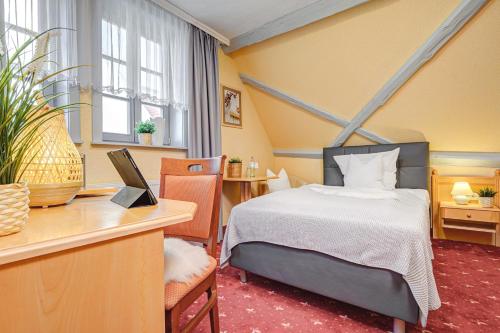 Mühlhäuser Hof- Stadtmauer- Rabe في مولهاوزن: غرفة فندقية فيها سرير ومكتب وكمبيوتر