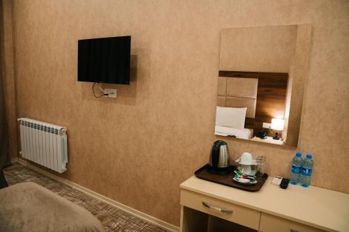 a hotel room with a bed and a mirror at The Clocktower Hotel in Baku