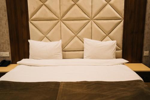 a bedroom with a large bed with white sheets and pillows at The Clocktower Hotel in Baku