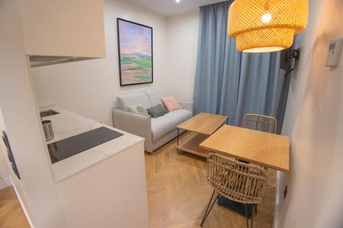 a kitchen and living room with a table and a couch at OIKOS APARTAMENTOS TURÍSTICOS in Monesterio