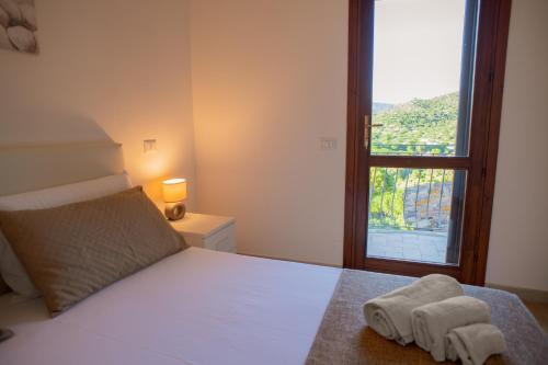 a bedroom with a bed with towels and a window at Cann'e Sisa Luxury Villa Perla Marina B in Torre delle Stelle
