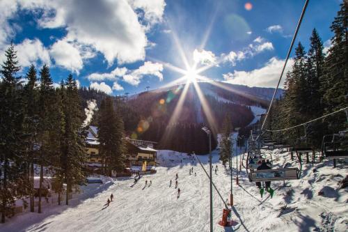 a group of people skiing down a ski slope at Ski & Wellness Residence Družba in Demanovska Dolina