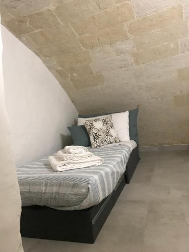 a bed in a room with a brick wall at I Venti in Taranto