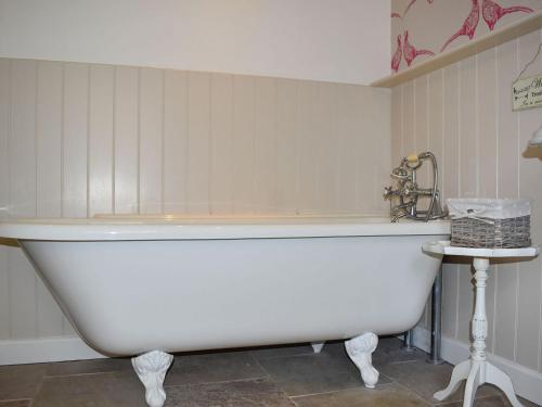 a white bath tub in a bathroom with a sink at Ysgubor Blaenparc Barn - Uk41030 in Mydroilin