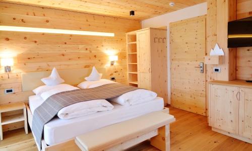 a bedroom with a bed in a wooden room at Chalet Elisabeth dolomites alpin & charme in Selva di Val Gardena