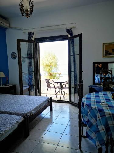 - une chambre avec un lit et une vue sur une terrasse dans l'établissement Maria's Studios blue, à Áfissos