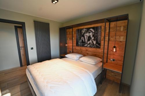 a bedroom with a large bed with a wooden headboard at Ard'view in Durbuy
