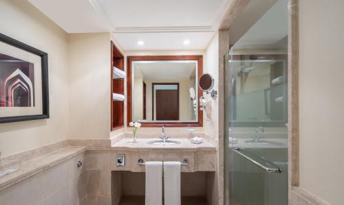 a bathroom with a sink and a shower at Movenpick Makkah Hajar Tower in Mecca
