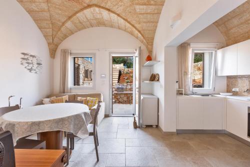 una cucina e una sala da pranzo con tavolo, una cucina e una sala da pranzo di Villa Tamerici by BarbarHouse a Torre Vado