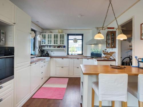 a kitchen with white cabinets and a wooden table at 7 person holiday home in Nakskov-By Traum in Nakskov
