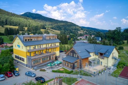 eine Luftansicht eines großen Hauses in den Bergen in der Unterkunft Hotel Helios in Lipová-lázně