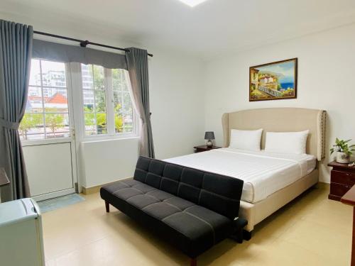 een slaapkamer met een bed en een bank erin bij LILA Hotel & Apartments in Ho Chi Minh-stad