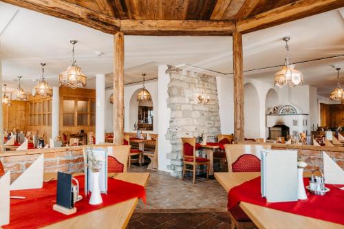 um restaurante com tectos e mesas e cadeiras de madeira em Hotel Grünwaldkopf em Obertauern