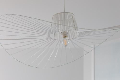 a white fan hanging from a ceiling at Apartments Mazowiecka Pobierowo by Noclegi Renters in Pobierowo