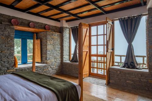 a bedroom with a bed and some windows at THE CEDAR CASTLE in Mukteswar