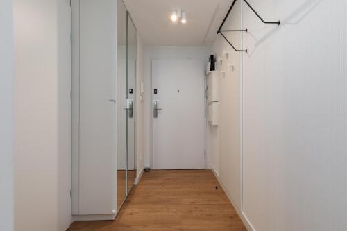 a hallway with white walls and a mirror at Apartments Mazowiecka Pobierowo by Noclegi Renters in Pobierowo