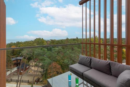 a living room with a couch on a balcony at Apartments Mazowiecka Pobierowo by Noclegi Renters in Pobierowo